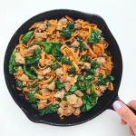 Sweet potato noodles, ground turkey, and wilted spinach in a cast iron skillet.