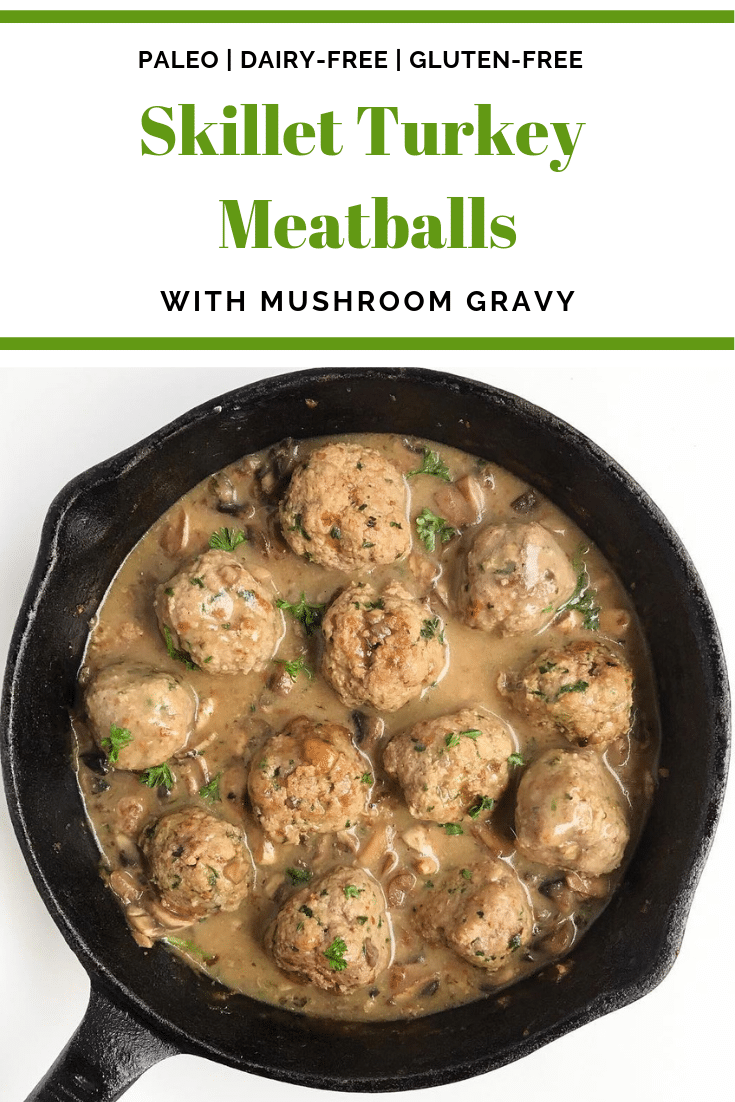 A cast iron skillet full of turkey meatballs and mushroom gravy