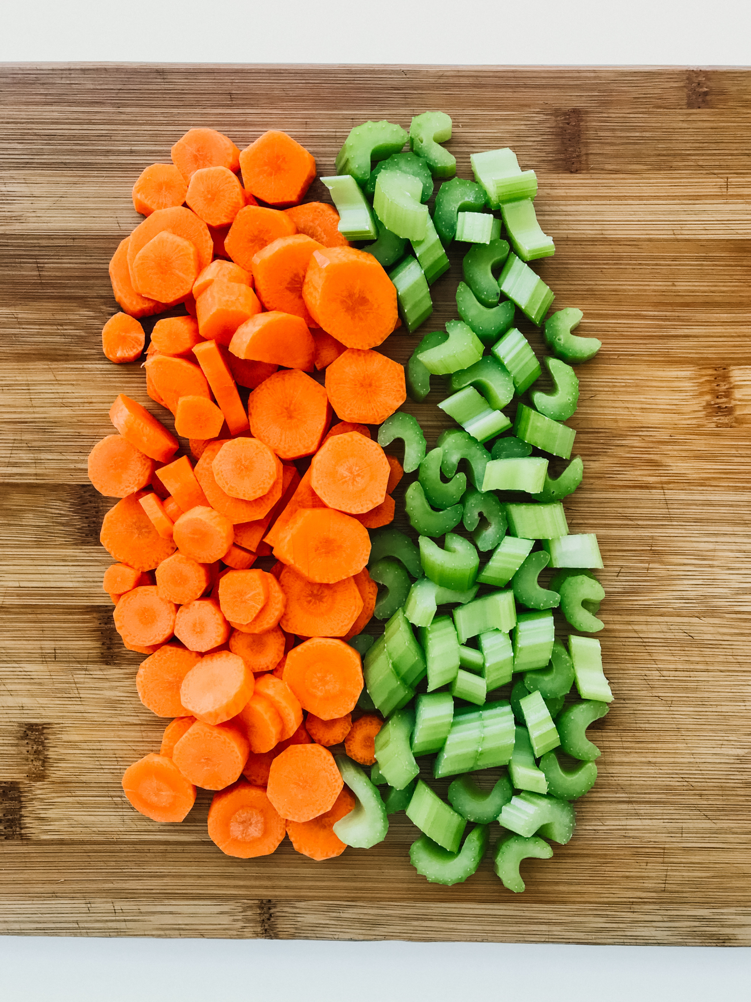 a cutting board with chopped carrots and celery