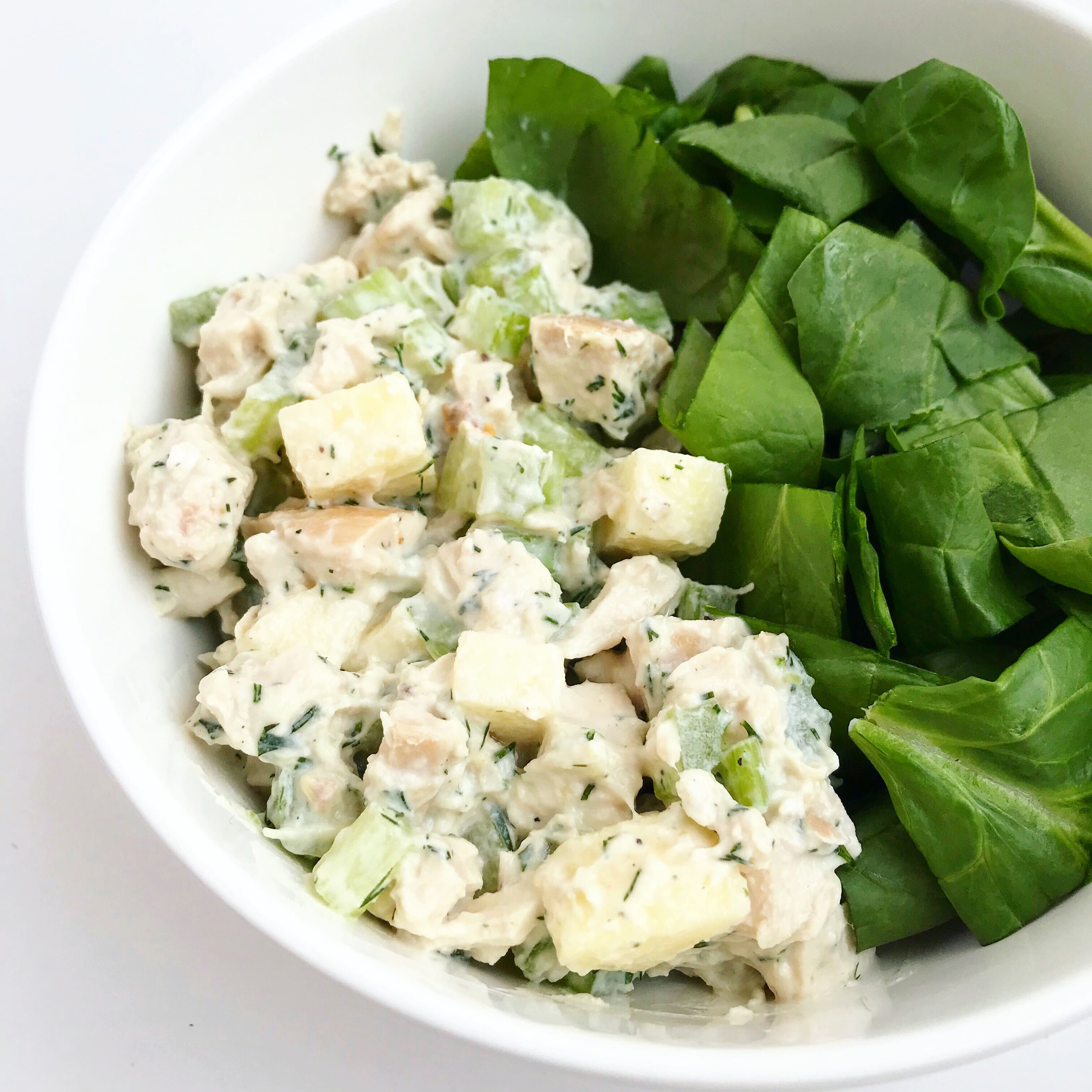 A bowl of Fresh Dill Chicken Salad with a side of fresh spinach.