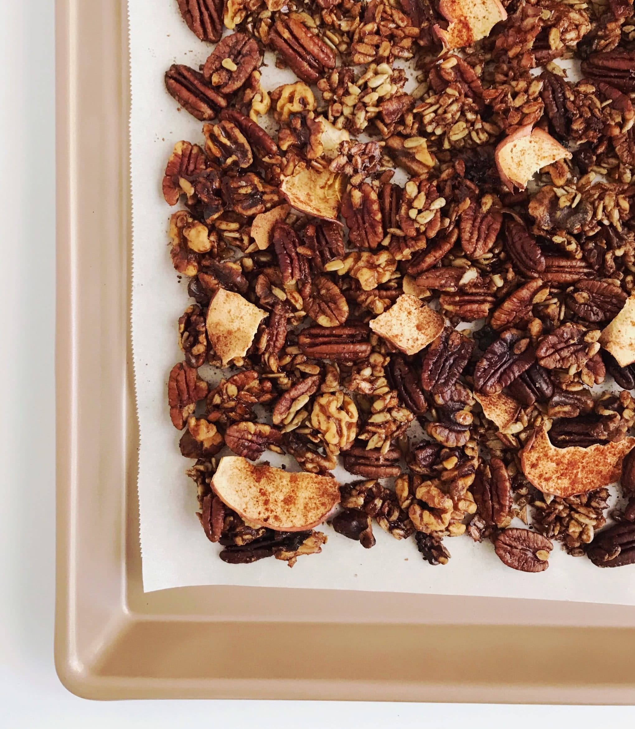 A copper baking sheet covered with grain-free cinnamon apple granola.