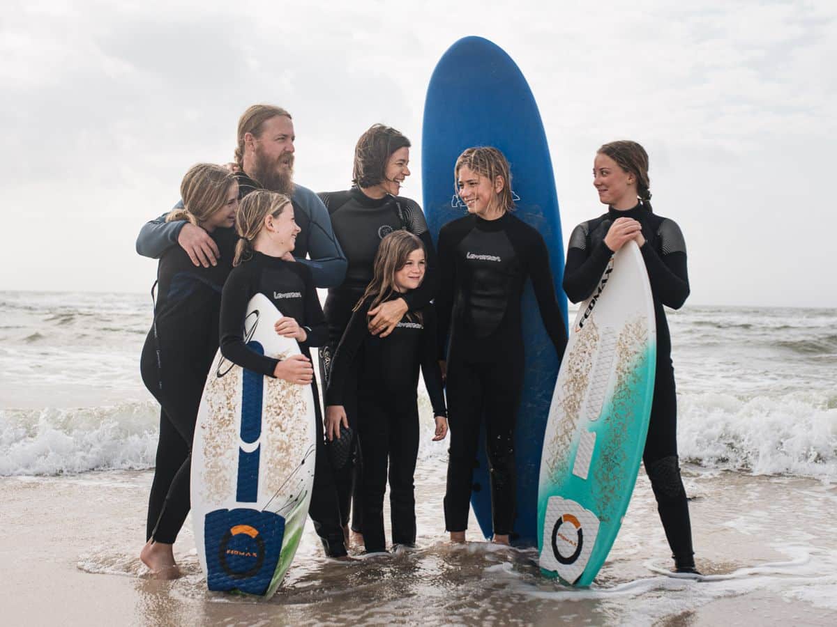 a family with surfboards on the beach