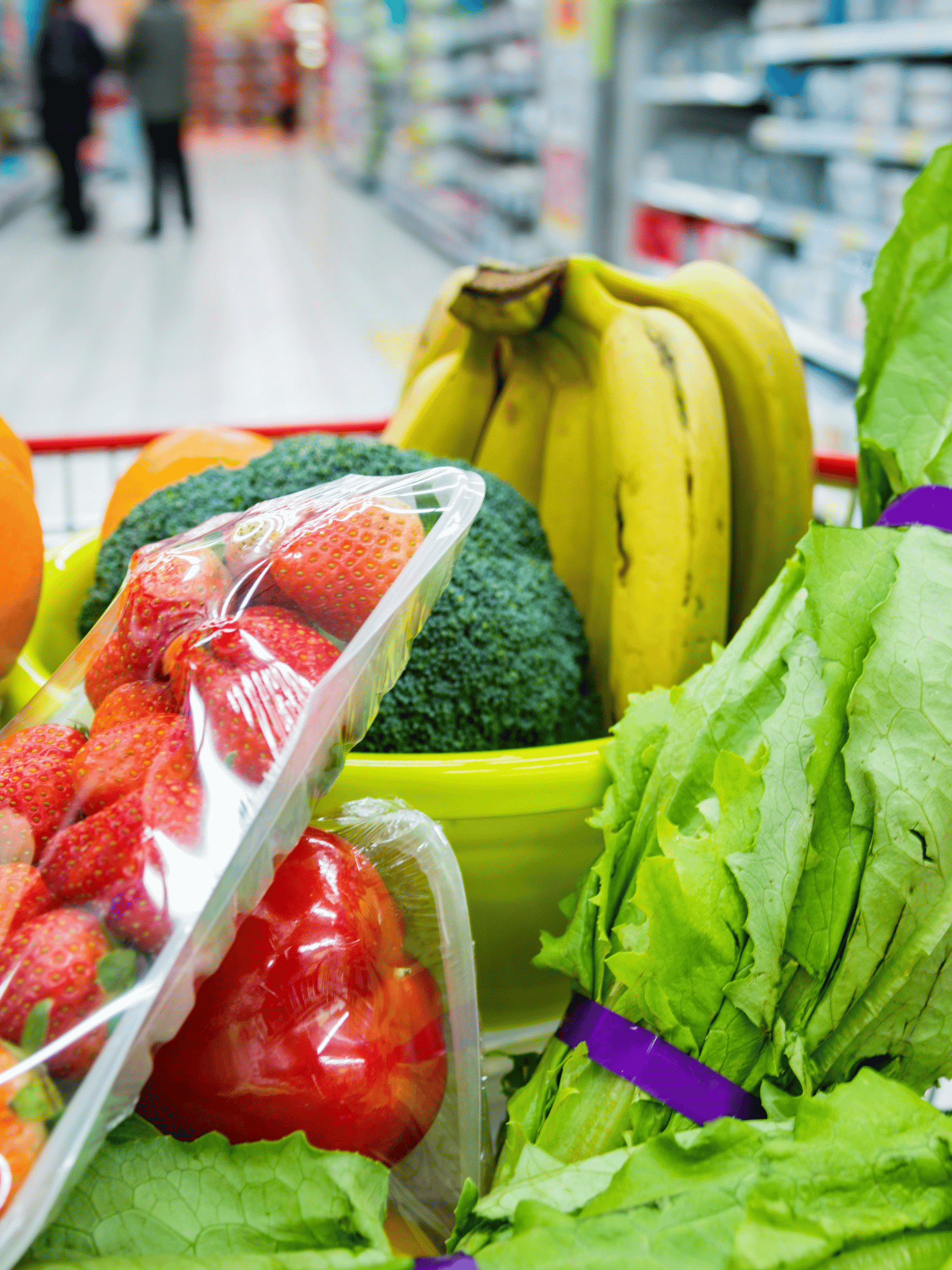 grocery cart full of lettuce, bananas, broccoli, peppers and strawberries