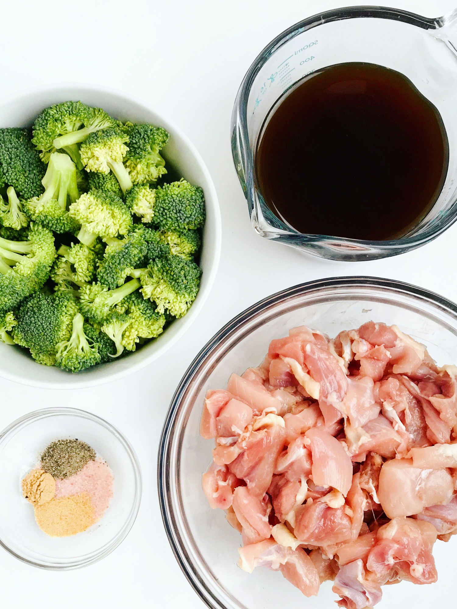 lean meat sliced in pieces in a bowl next to raw broccoli, a bowl of tamari and a bowl of seasonings. All food that would be simple and delicious for a GERD friendly diet