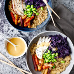 Two bowls filled with colorful ingredients sit on a marble table