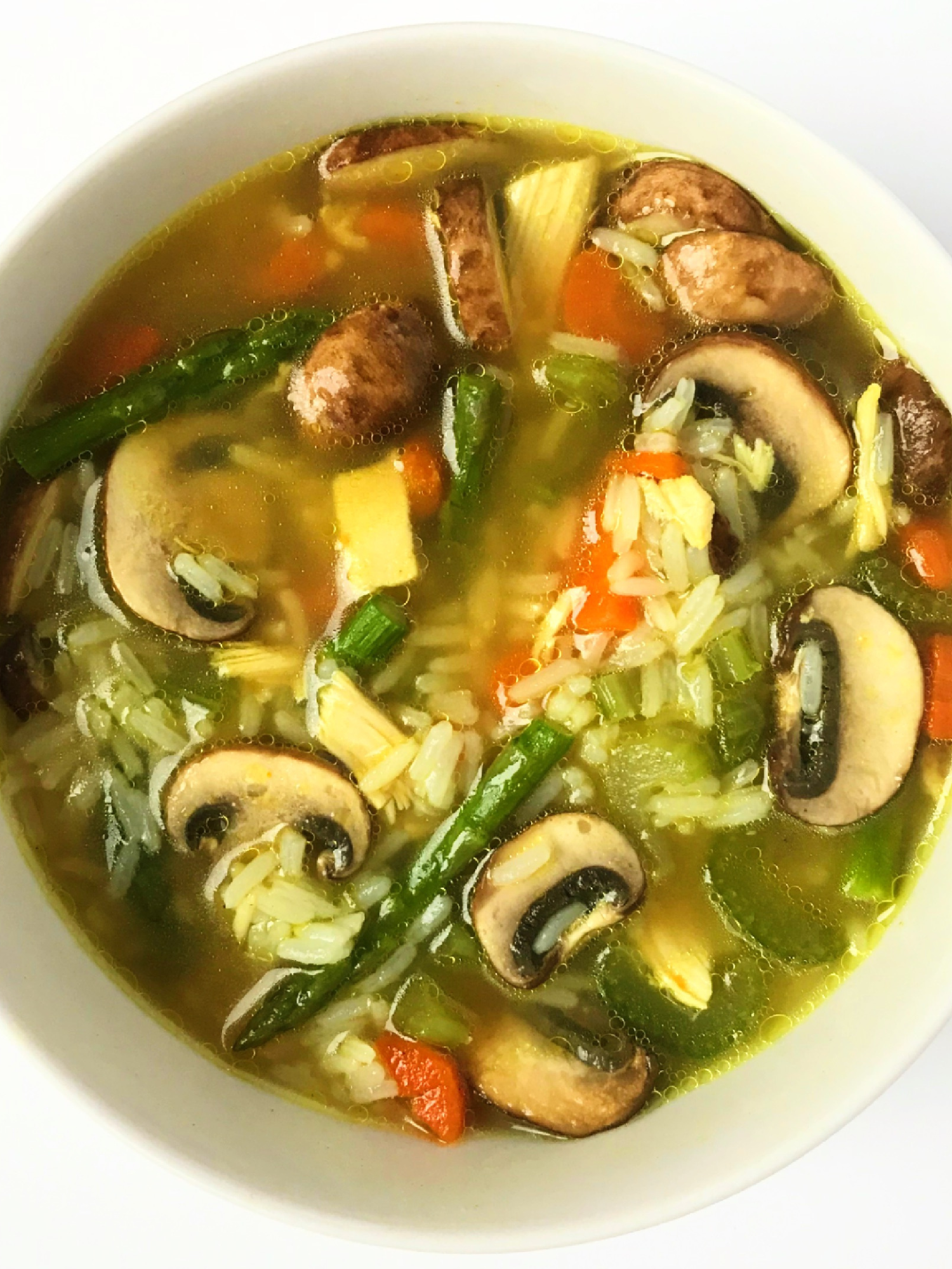 A big white bowl of hearty chicken, rice and vegetable soup