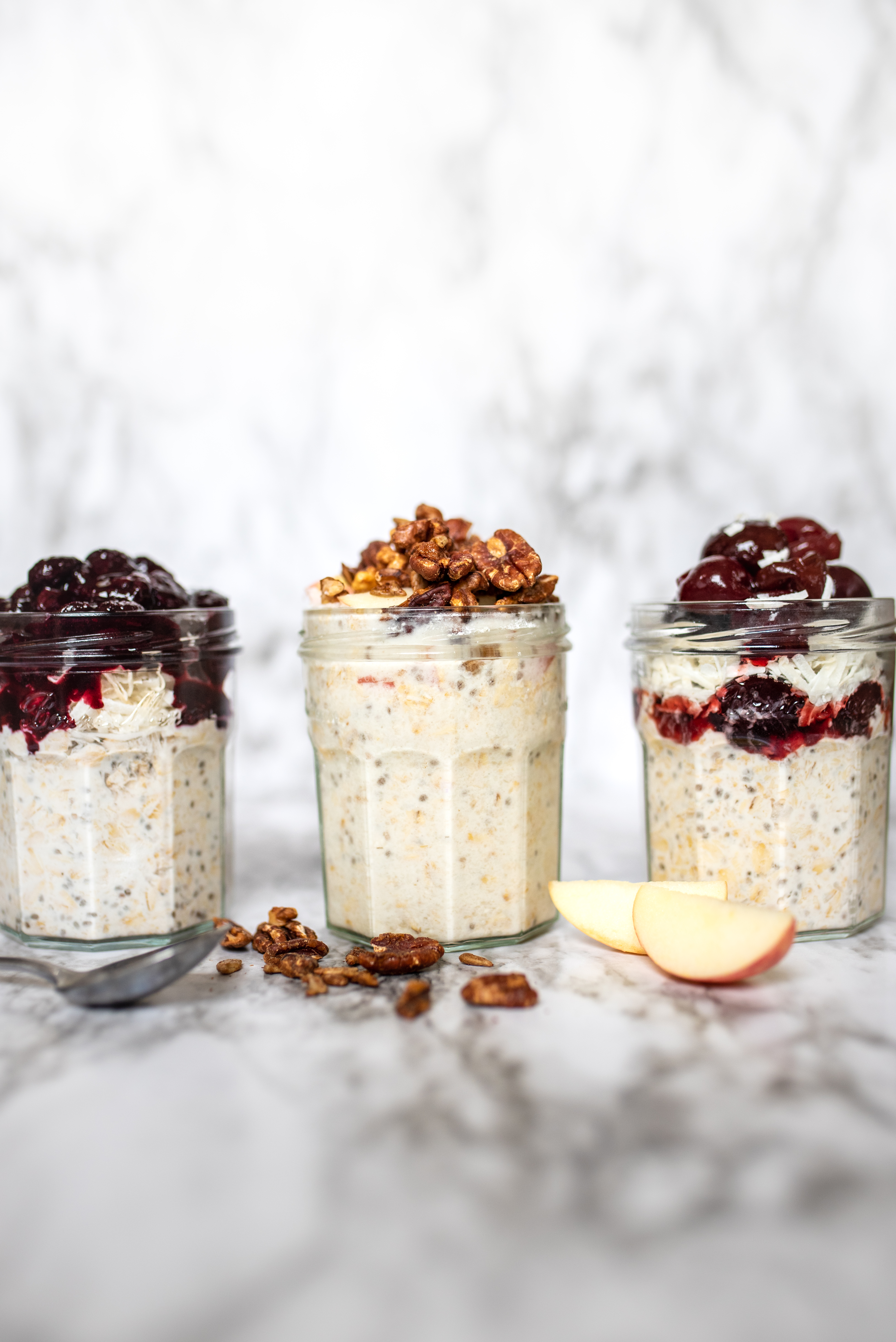 Three jars of coconut milk overnight oats with three different varitaions of toppings and flavors