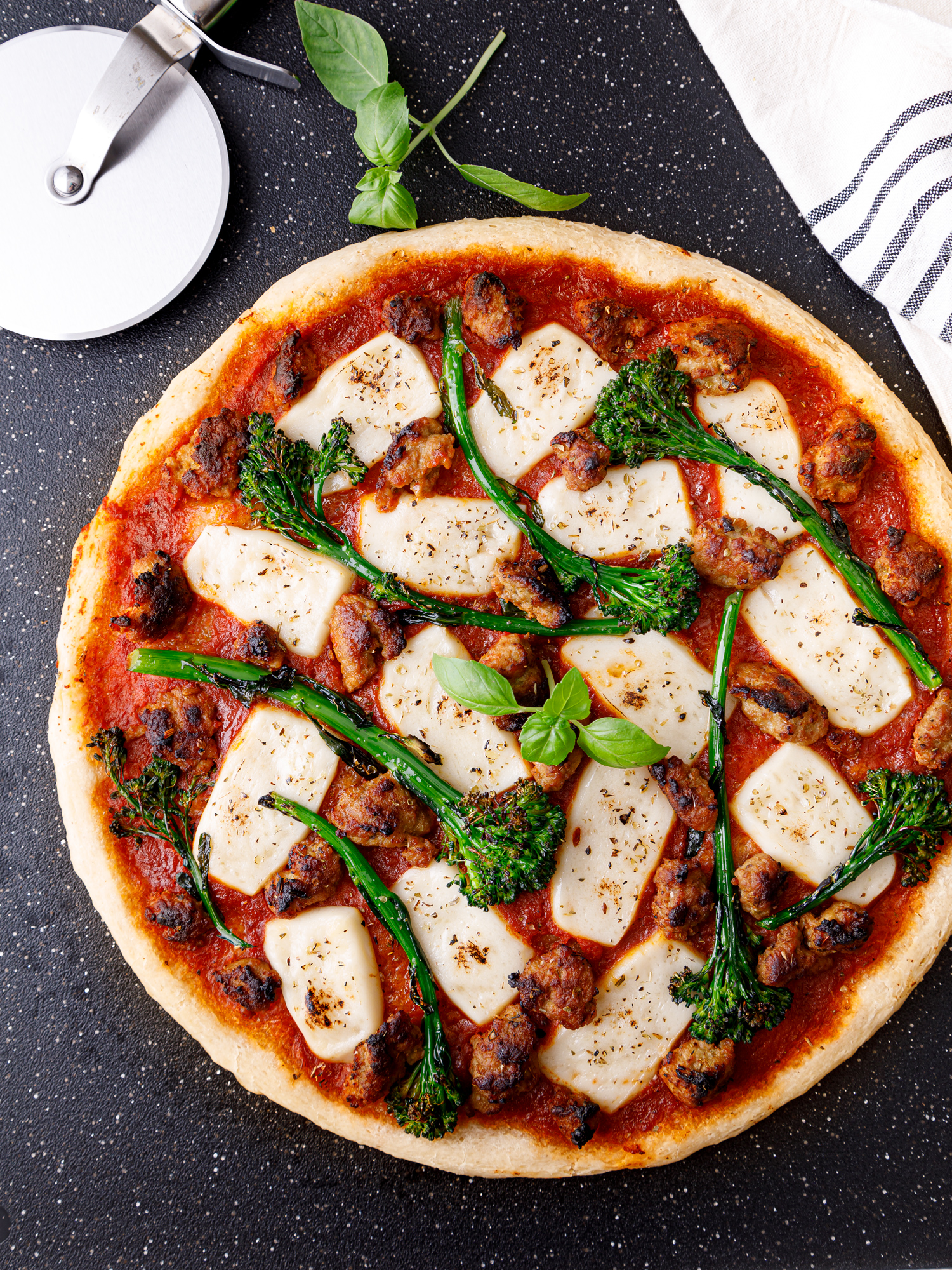 a gluten free pizza crust topped with no tomato sauce and topped with broccoli, ground turkey and vegan mozzarella