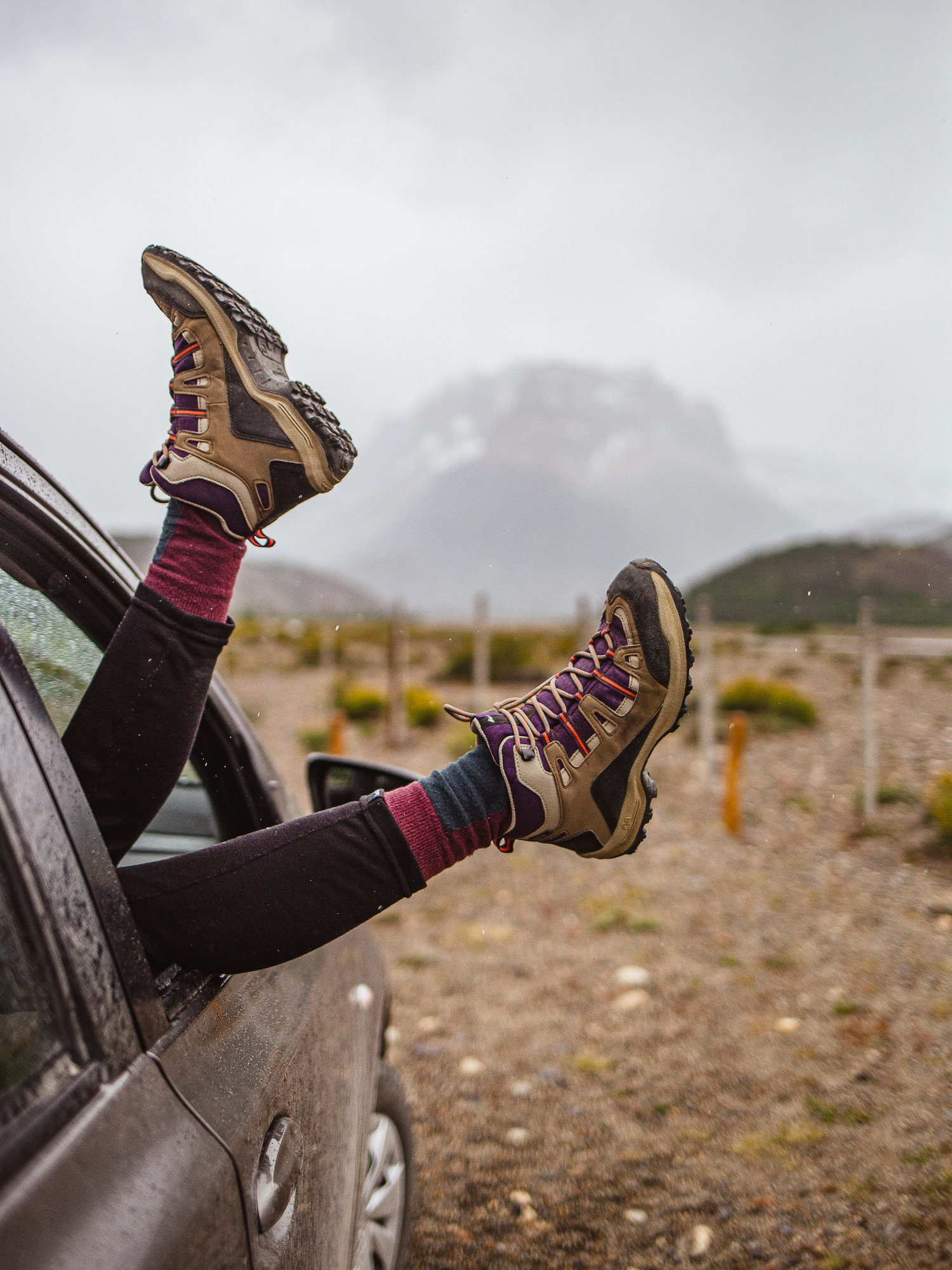 two legs handing outside a car window with incredible scenery behind