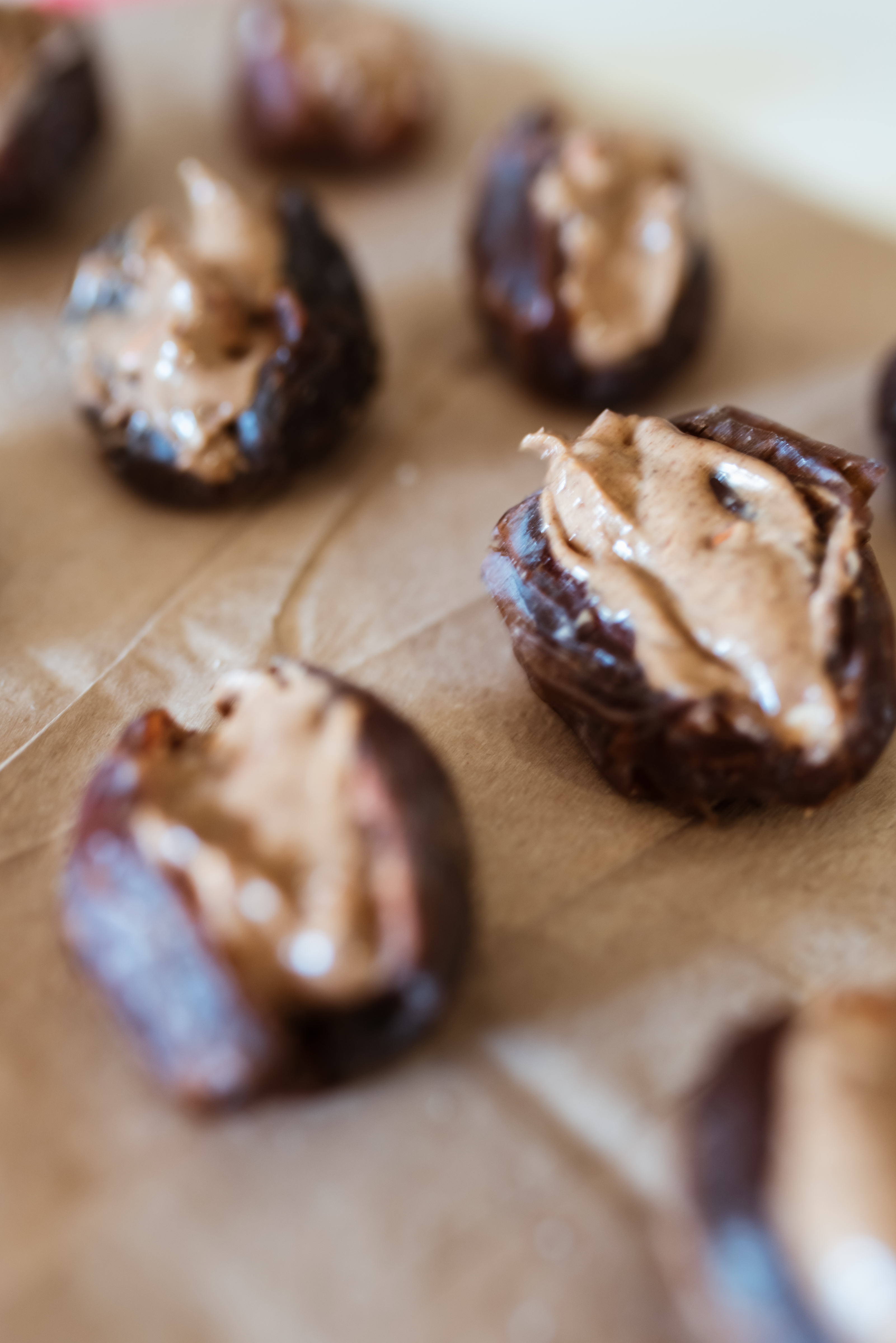mejool dates stuffed with almond butter and layed on on brown paper