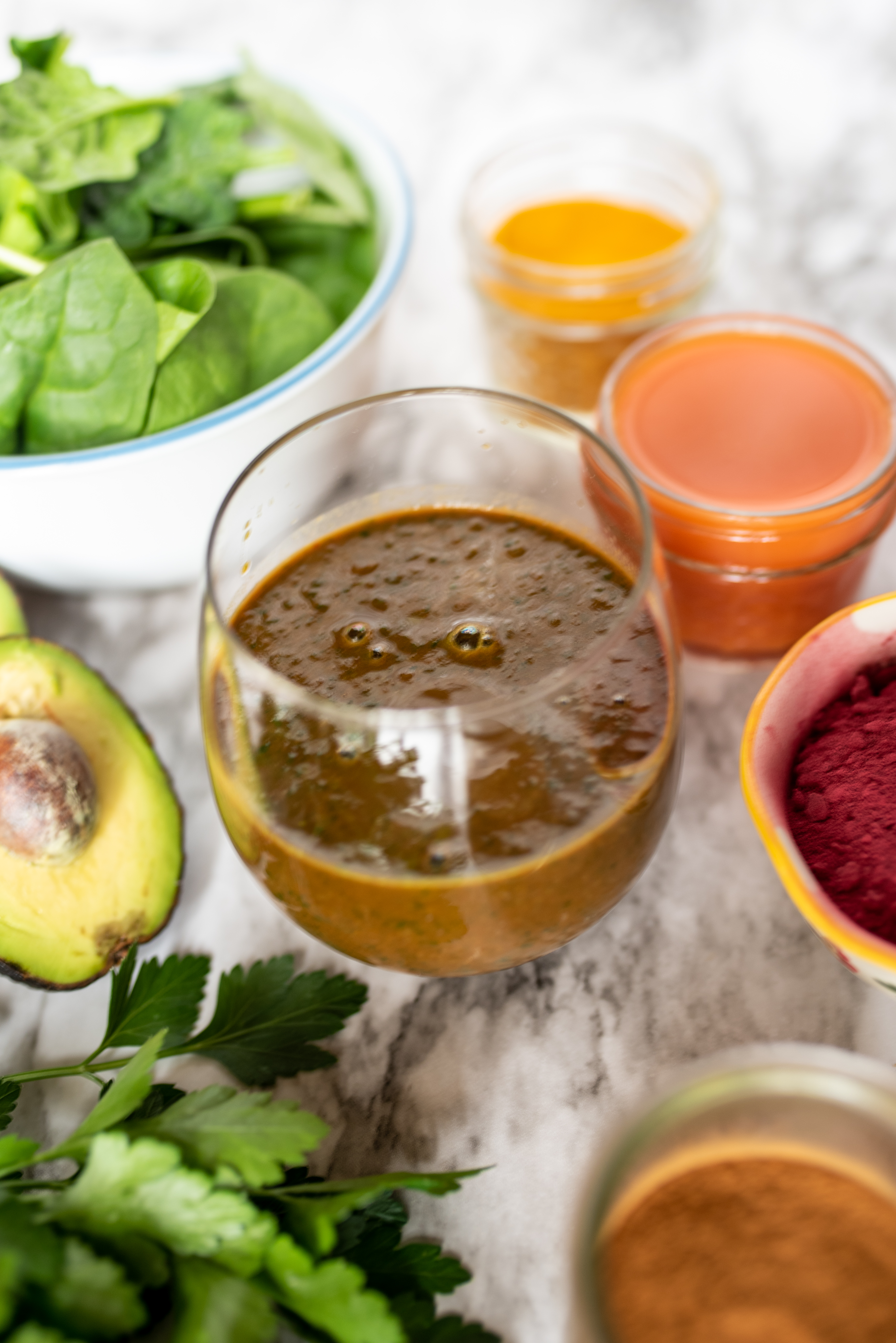 brown juice in clear glass surrounded by ingredients