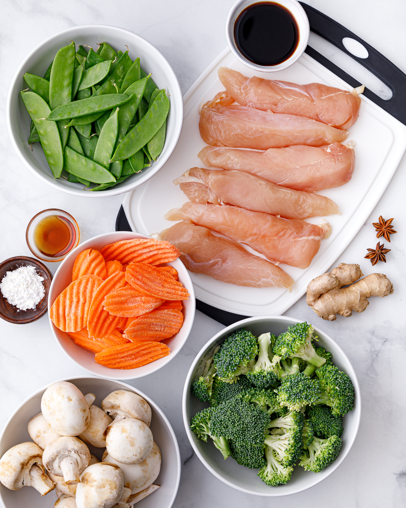 healthy raw ingredients of chicken carrots, broccoli, and mushrooms