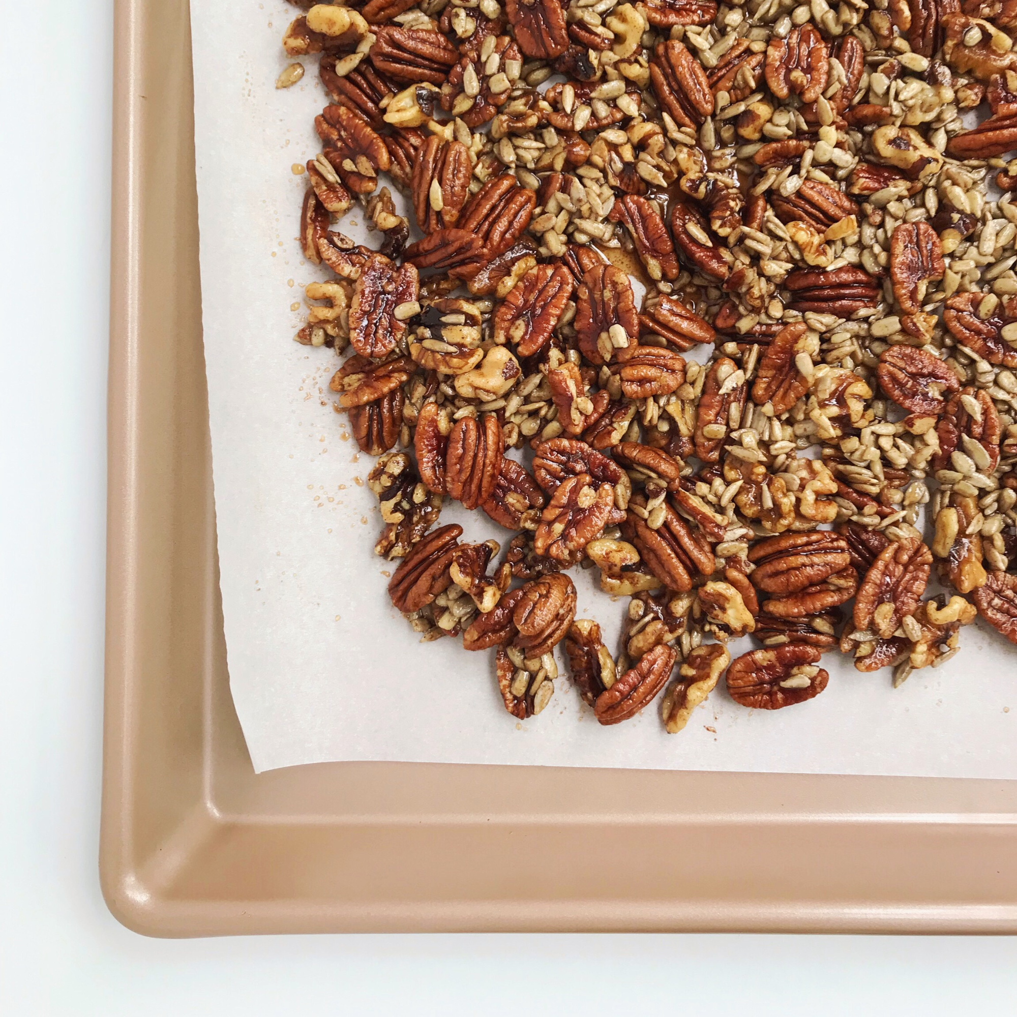 a parchment lined baking sheet of apple cinnamon baked granola