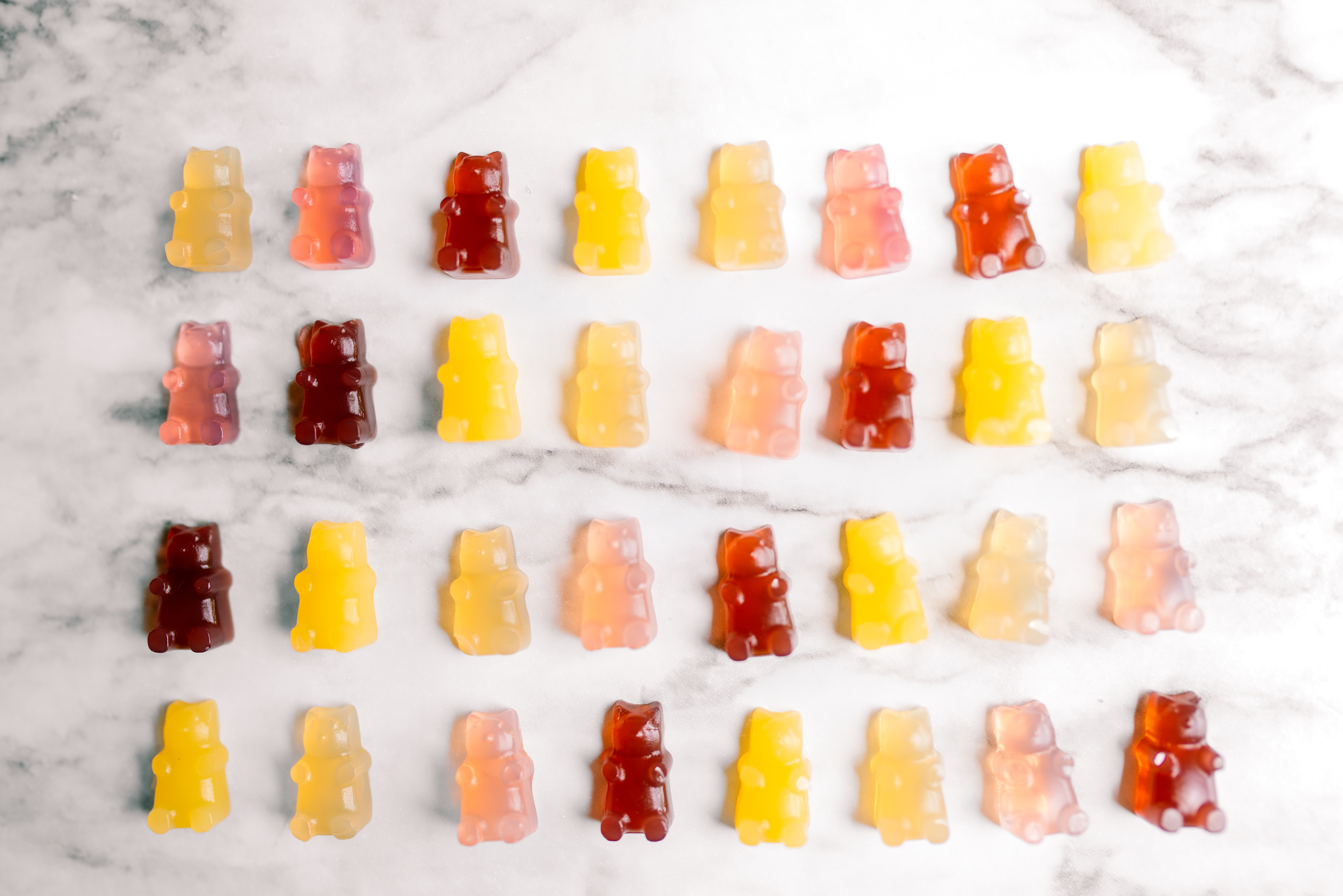 four lines of different colored gummy bears all in neat rows