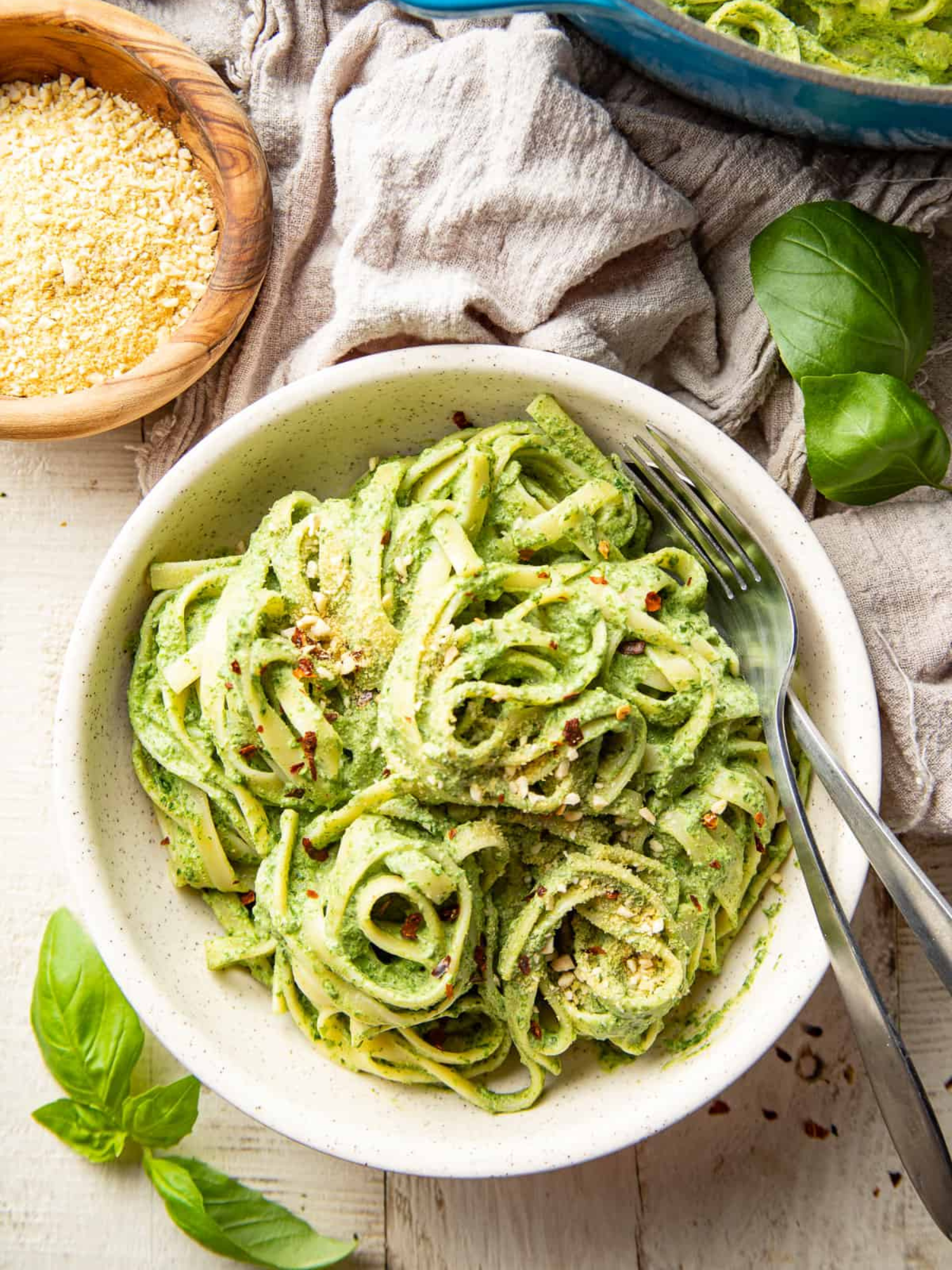 a white bowl filled with delicious creamy vegan spinach pasta