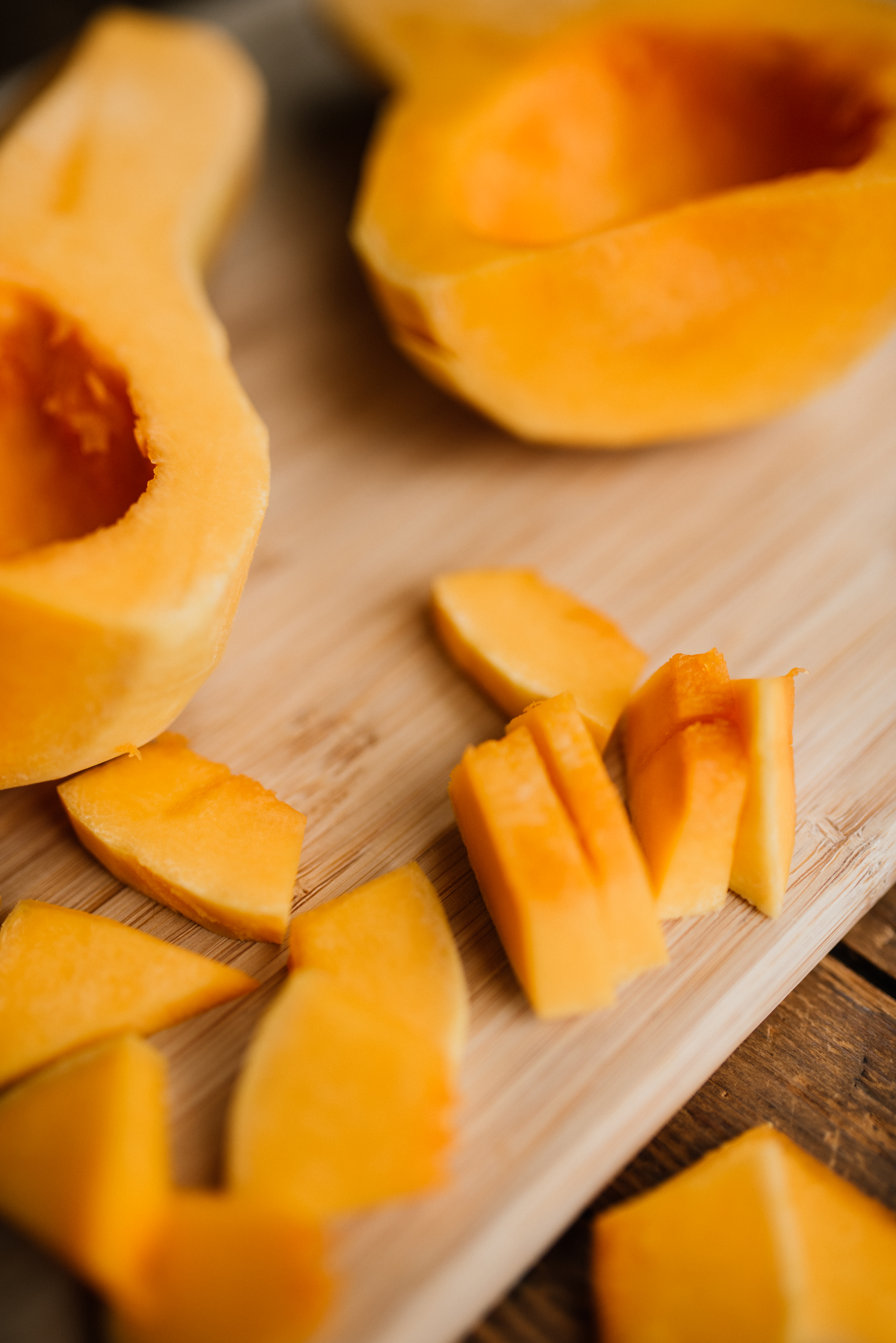 a butternut squash peeled, cut in half and then in 1/2 inch slices on a cutting board