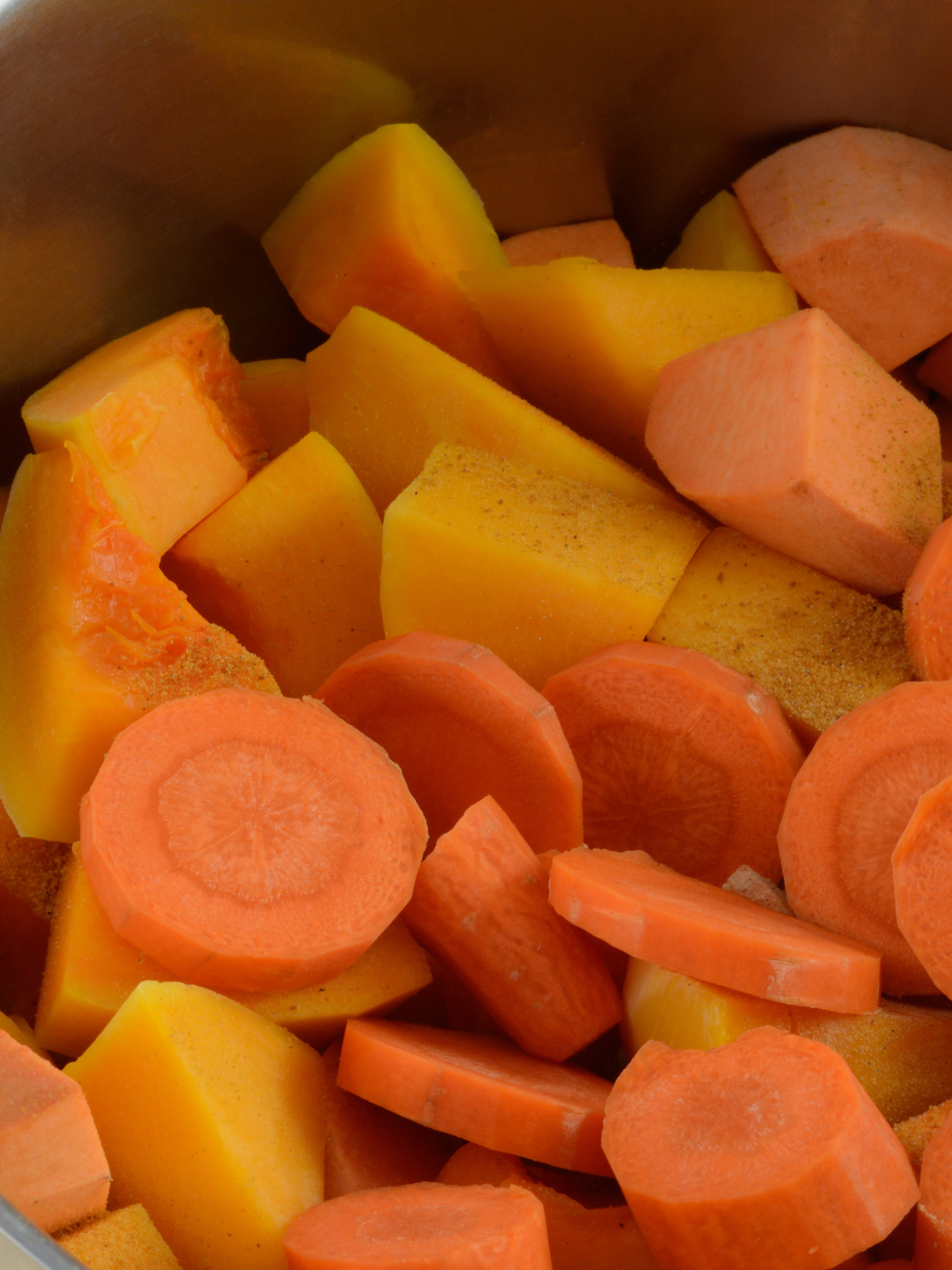 a crockpot full of chopped and cubed butternut squash and chopped carrots
