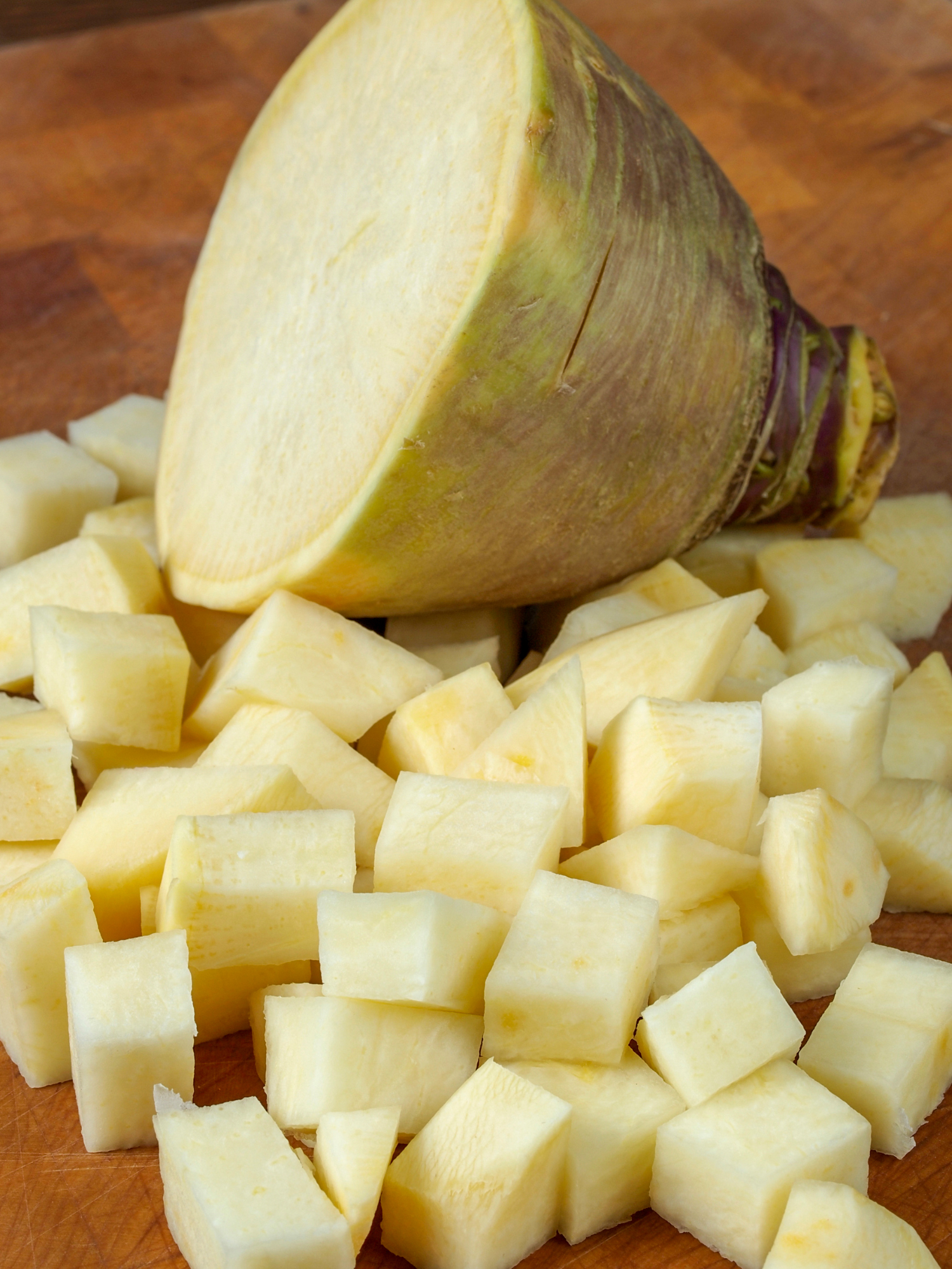 a rutabaga that is partially diced on a cutting board